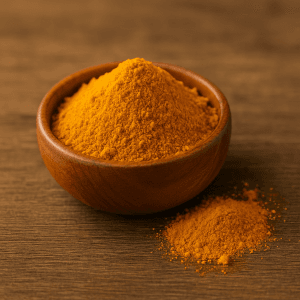 Curcuma en poudre bio dans un petit bol en bois avec des racines de curcuma fraîches en arrière-plan, utilisé comme épice et complément naturel anti-inflammatoire.